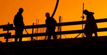 Construction Workers in Setting Sun